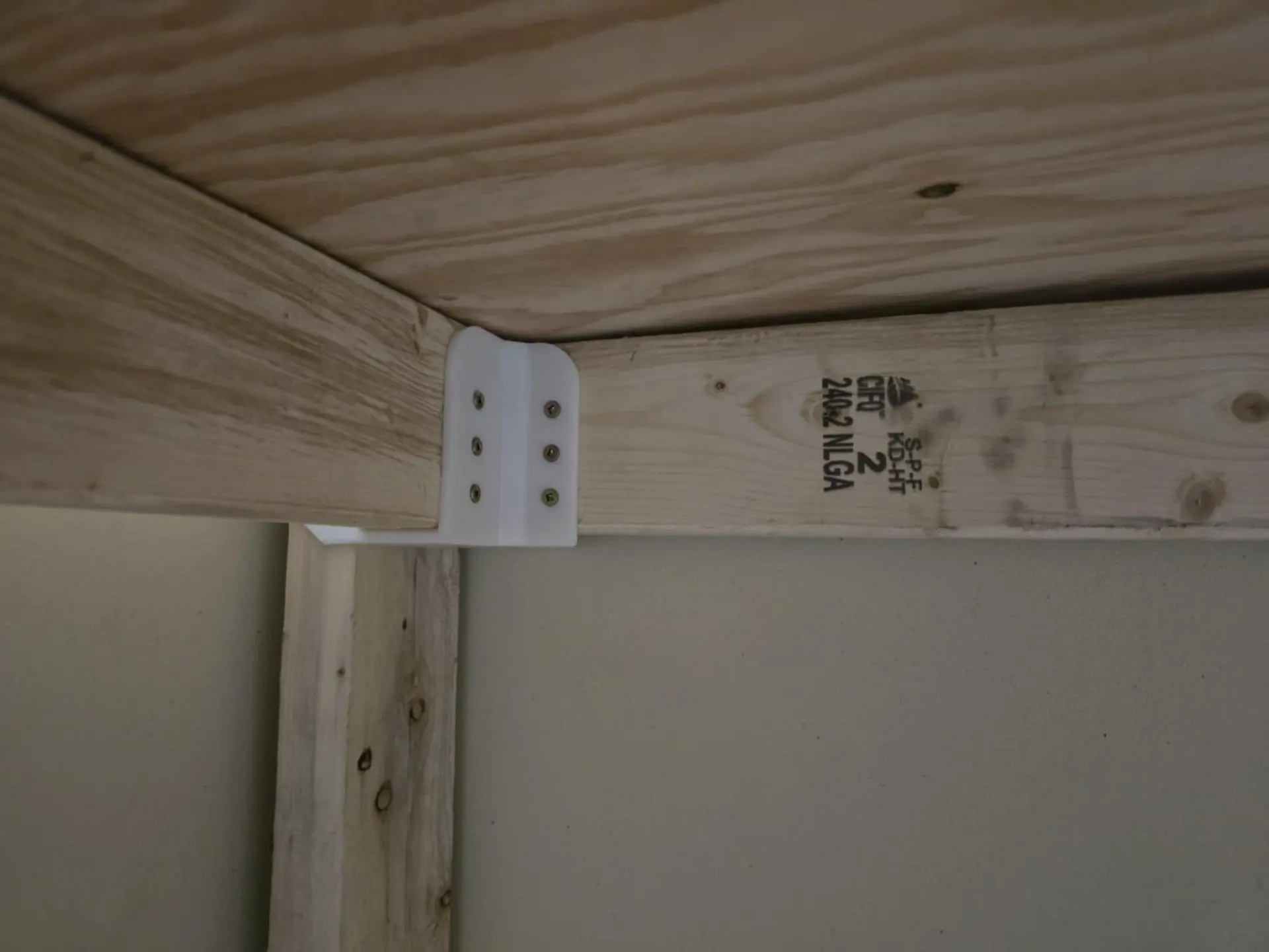 Custom 3D-printed shelf support bracket reinforcing a wooden cabinet corner, FDM print